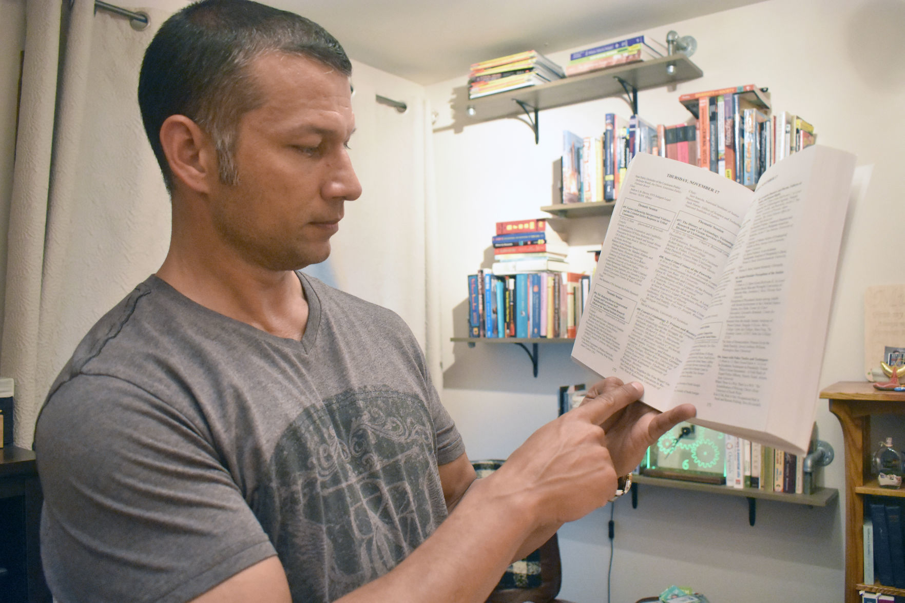 Ryan Ramnarace shows book in office